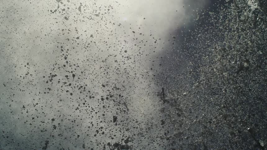 Water droplets suspended in the air after an impact in the ocean illuminated by sunlight