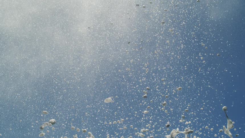 Upward view of foaming water against a blue sky