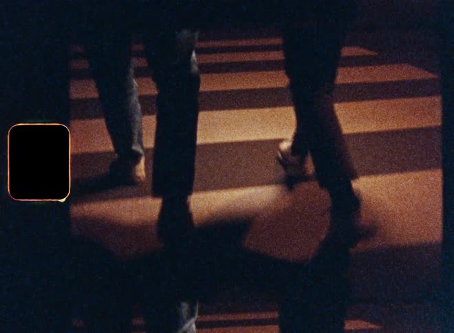 People are walking on a crosswalk across a road at night