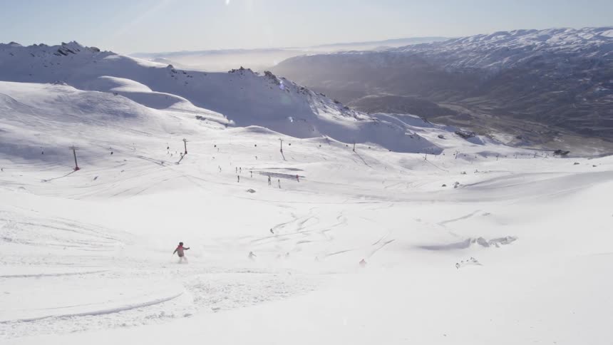 Skiers descent a snowy mountain
