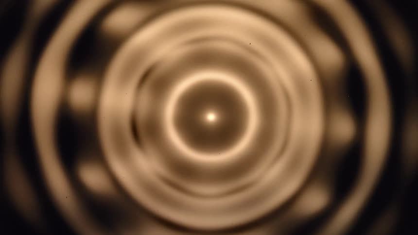 Abstract shapes of pulsating golden light on a brown background