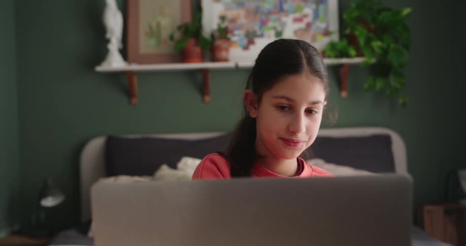 Girl sitting in a room in front of a laptop