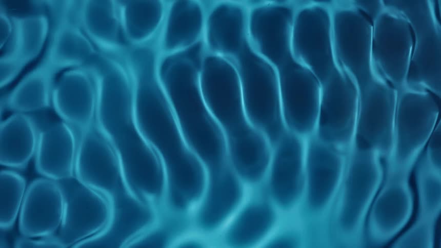 Water Cymatics, A pattern of blue light reflections on water creates wavy interconnected lines