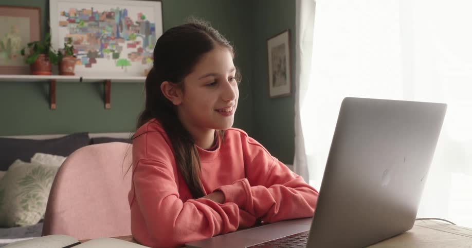 Girl sitting in front of a laptop with a happy facial expression