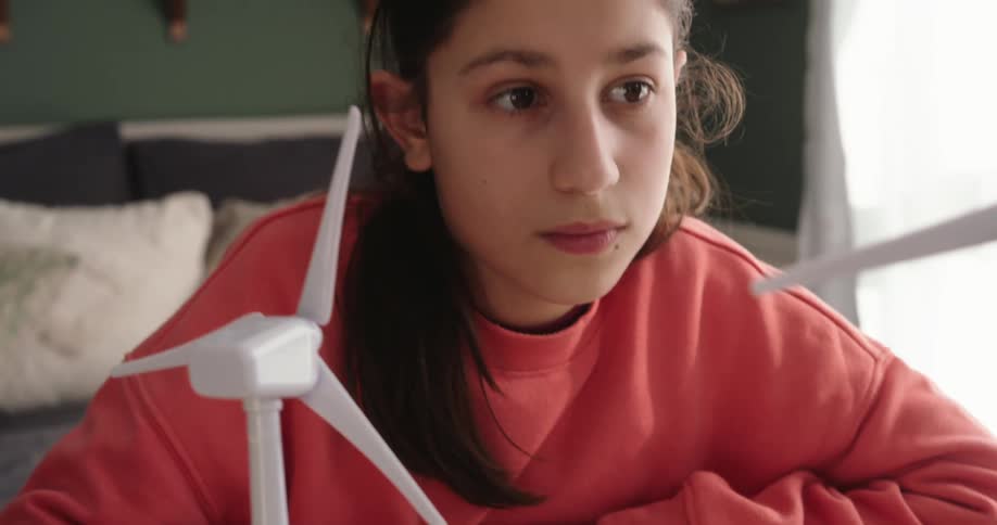 A girl is writing and drawing in a book with a pen