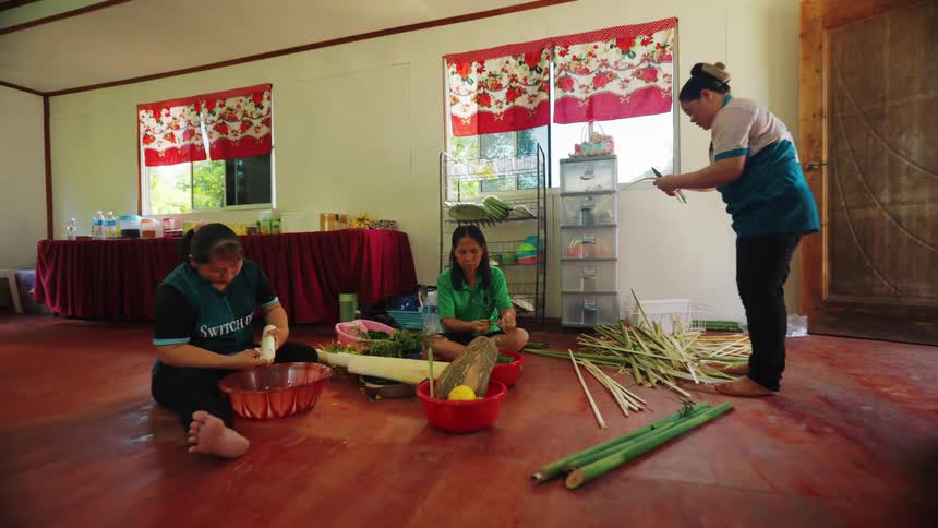 Women are working while they peel long logs in the room