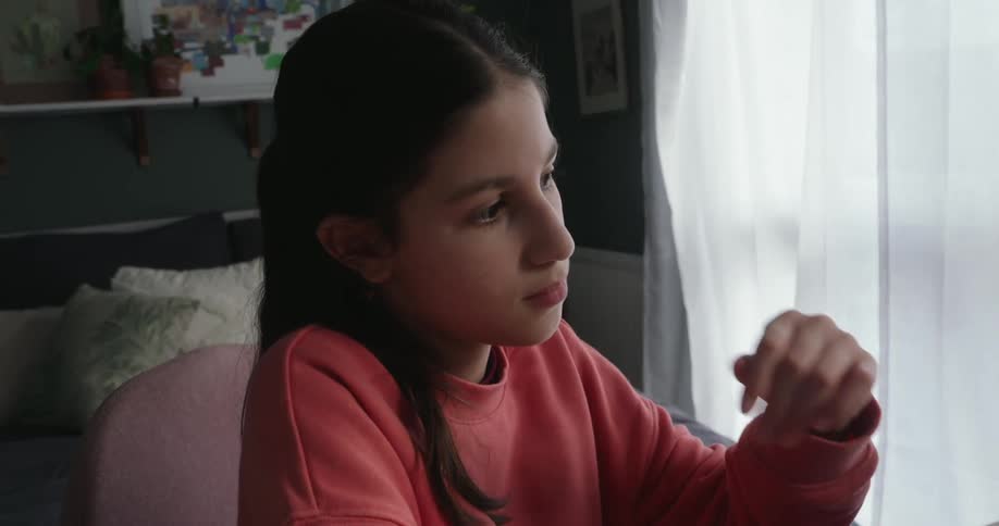 Girl typing on a laptop and then putting her hand on her mouth in thought