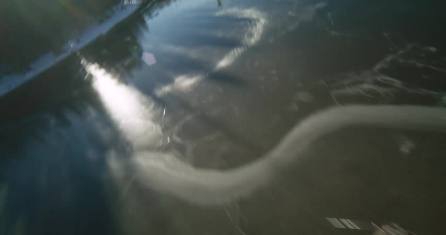 Two people playing hockey on a frozen lake seen from above
