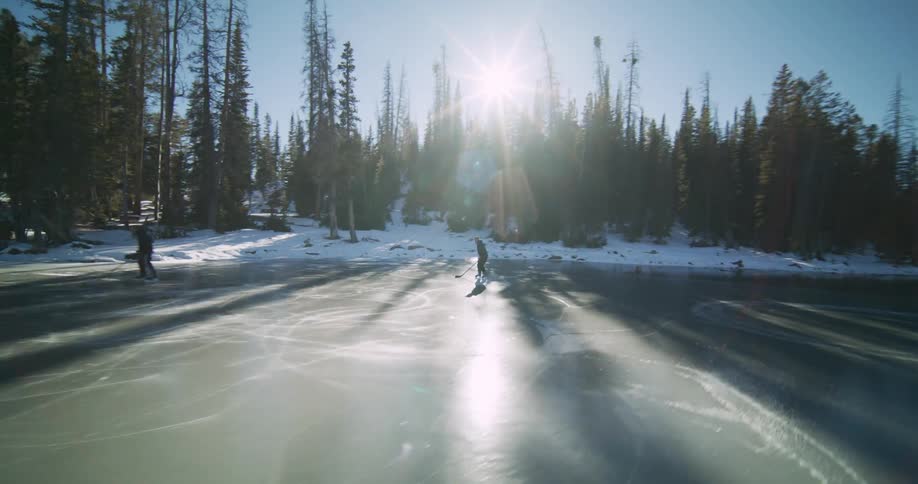 Two people skating on a frozen lake