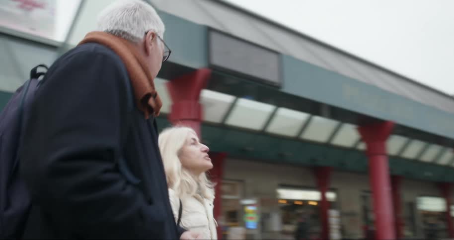 Older couple smiles and talks together while looking at an abstract outdoor sculpture