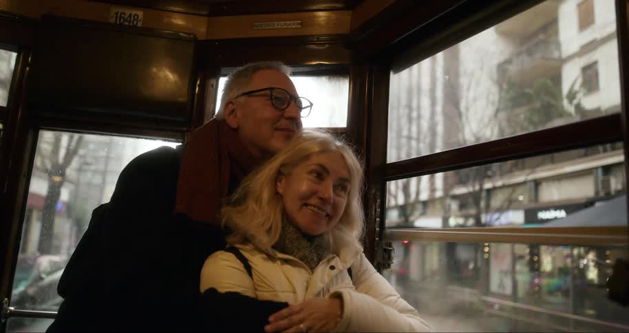 Couple hugging each other affectionately on public transport