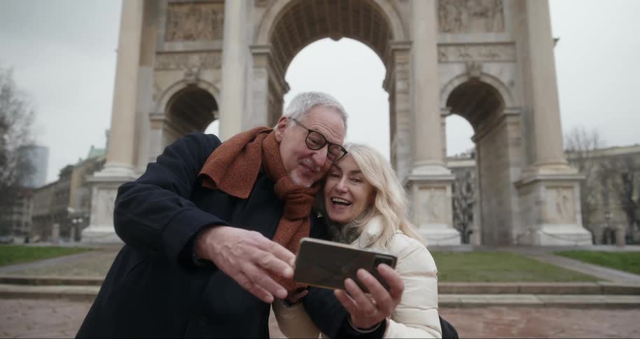 Happy couple taking a selfie while standing at a historical monument