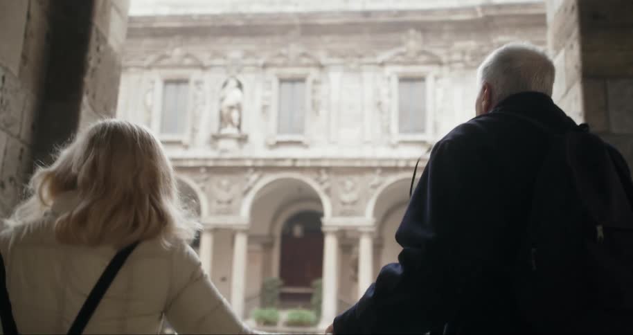 Couple holding hands walking together through a classic building