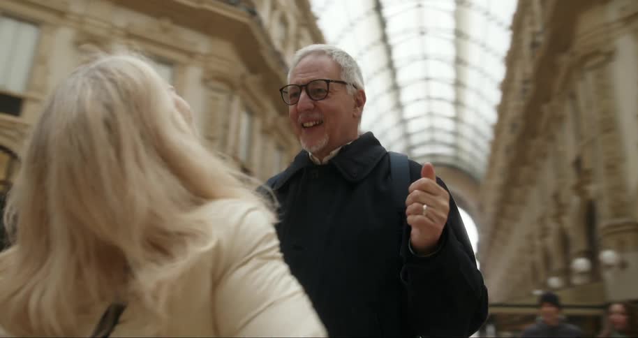 A happy couple admires the architecture of a grand shopping arcade