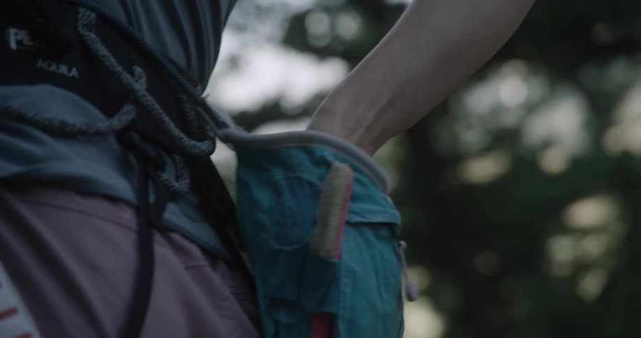 Climber reaches for the chalk in her chalk bag as she prepares for the climb