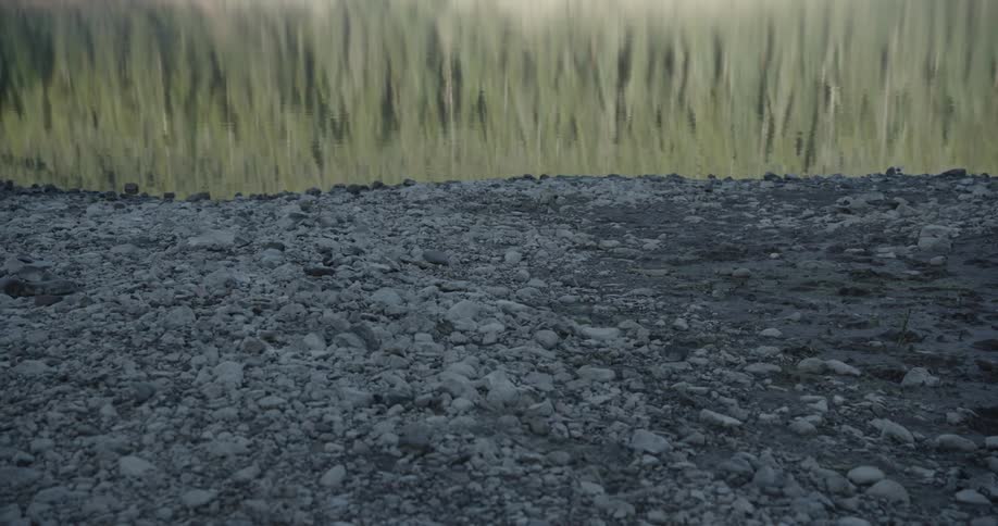 Gravel covers the ground near a field during the day