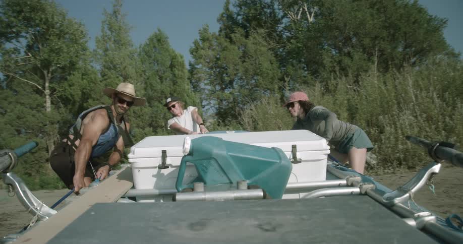 Friends cooperate to move a boat on a sunny summer day