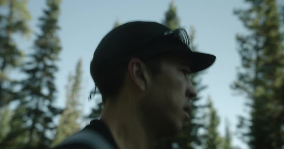 Man in cap running down a forest trail