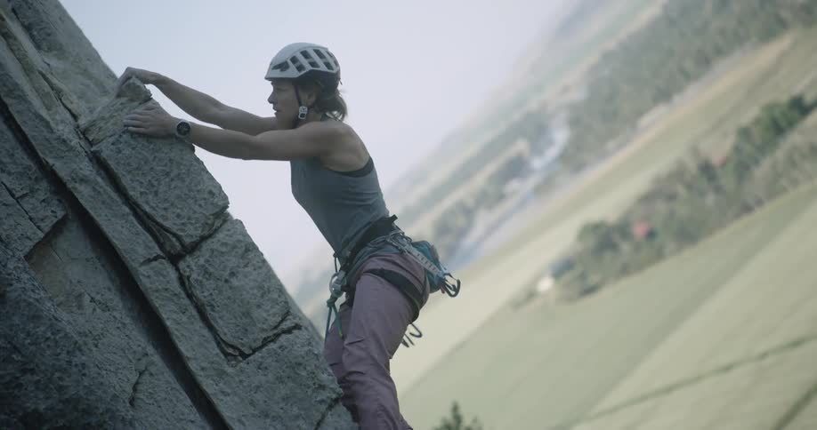 Woman in helmet climbing a rock wall