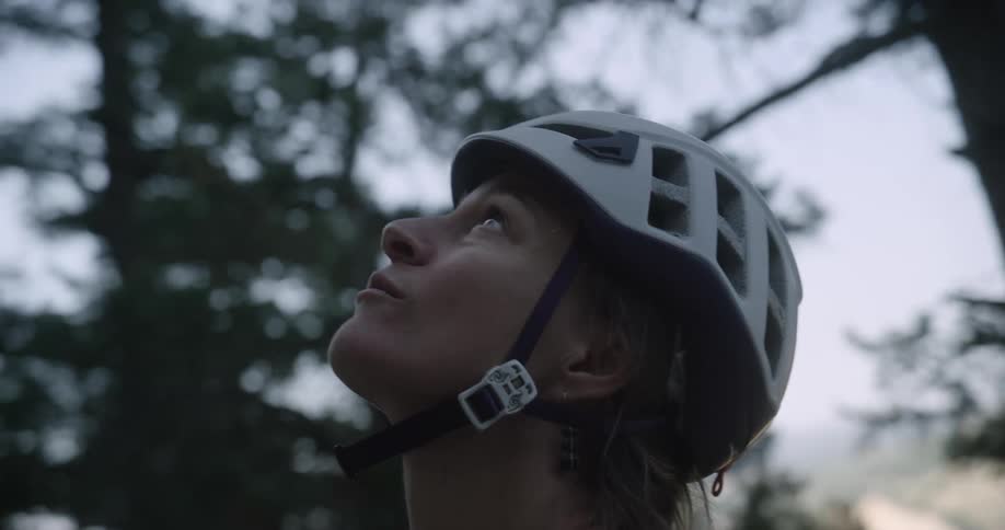 The face of a woman who is wearing a helmet attached to her neck and she is looking up