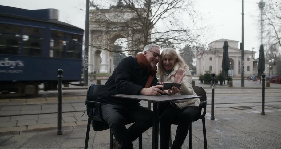 Two tourists are on a video call as a trolley passes them by