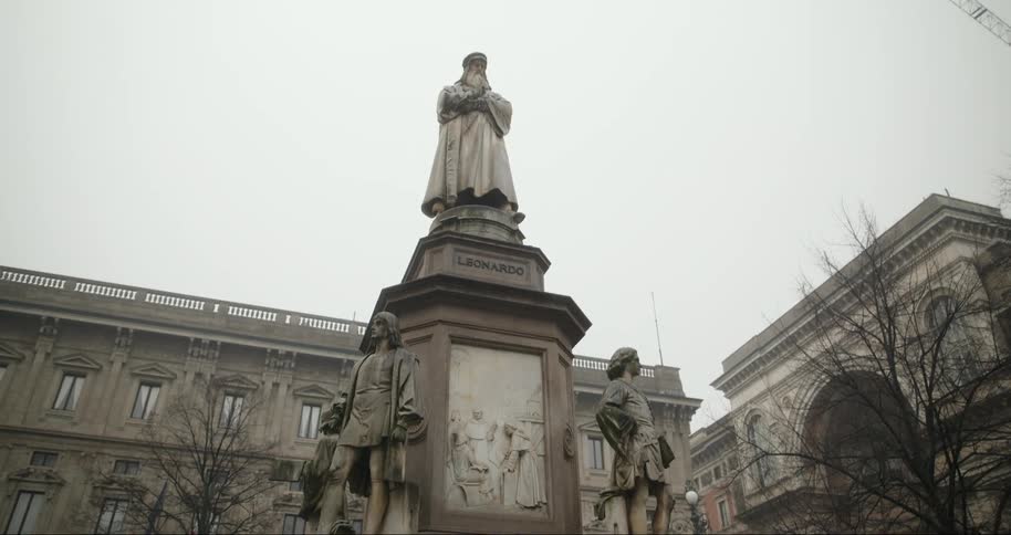 Statue in the center of a city with classical buildings