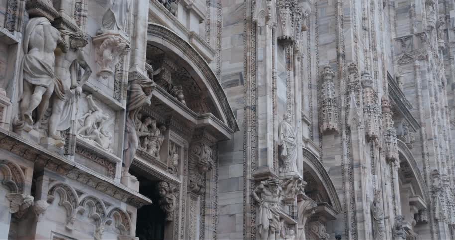 Religious sculptures and other stone carvings decorate the outside of a historic religious building