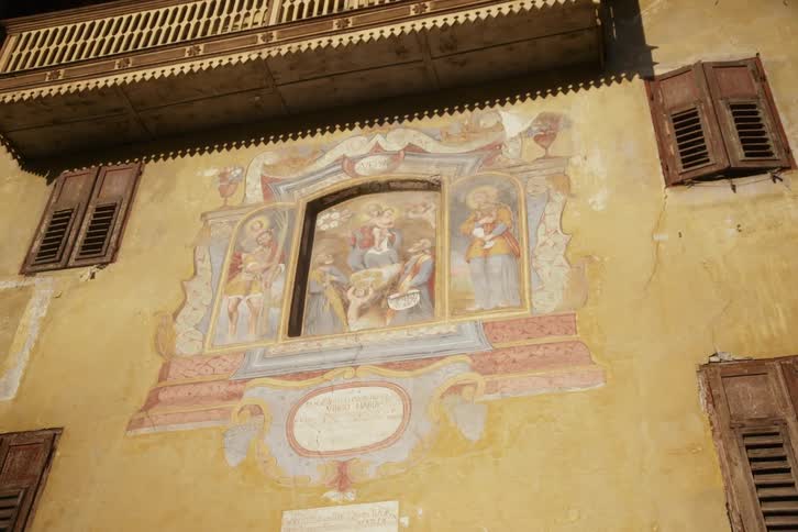 Wall of a worn classical building with a renaissance painting