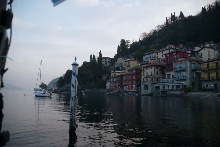 A boat is docked by the shore of the small town
