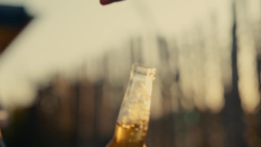 Hand with opener opening a beer