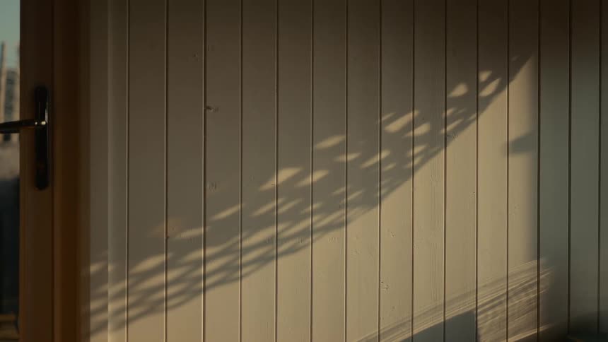 Close up of a wall and door with sun reflection and shadow