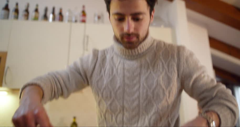Man places pasta on a plate in his kitchen