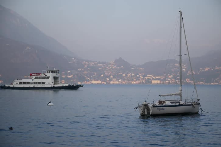 Yacht moored at sea with a moving ferry boat in the background
