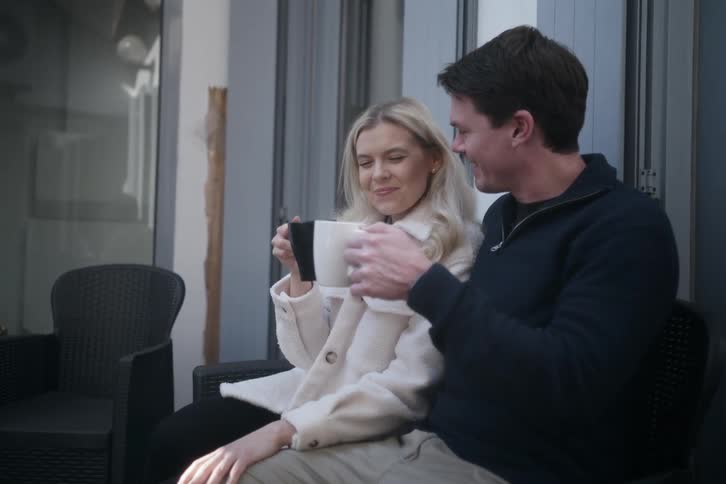 Couple toasting two mugs and kissing