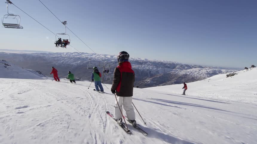 Group of kids skiing down a hill
