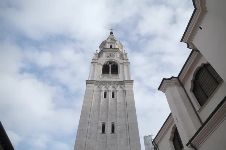 White tower of a church against a blue sky with clouds
