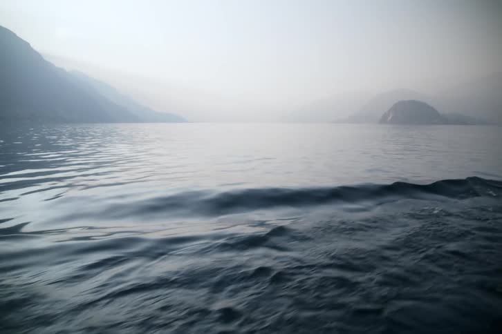 Small waves ripple across the water near mountainous islands