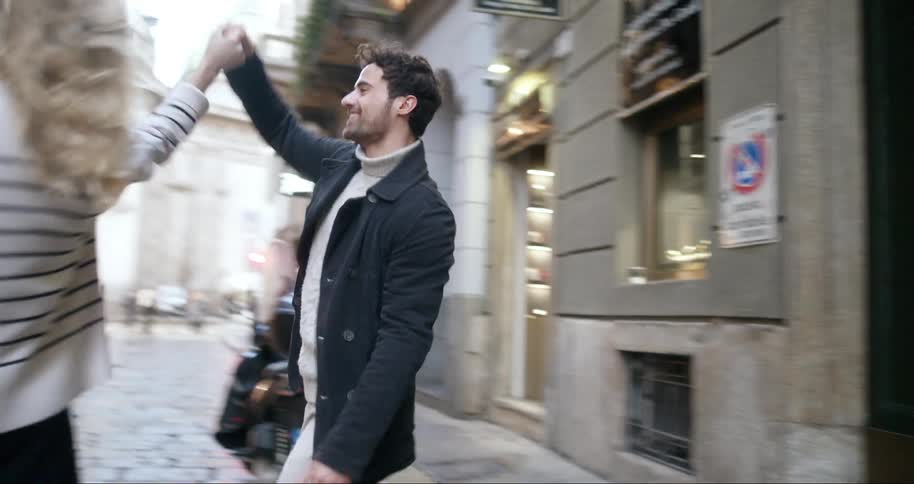 A footage of a man and a woman running out a door and dancing