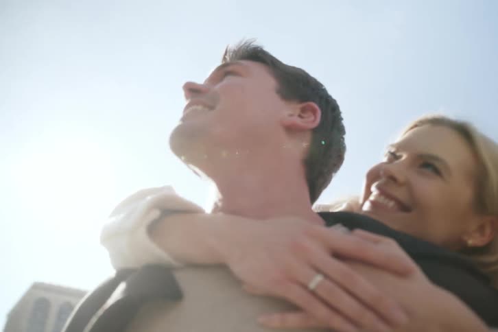 A woman is hugging a man from behind