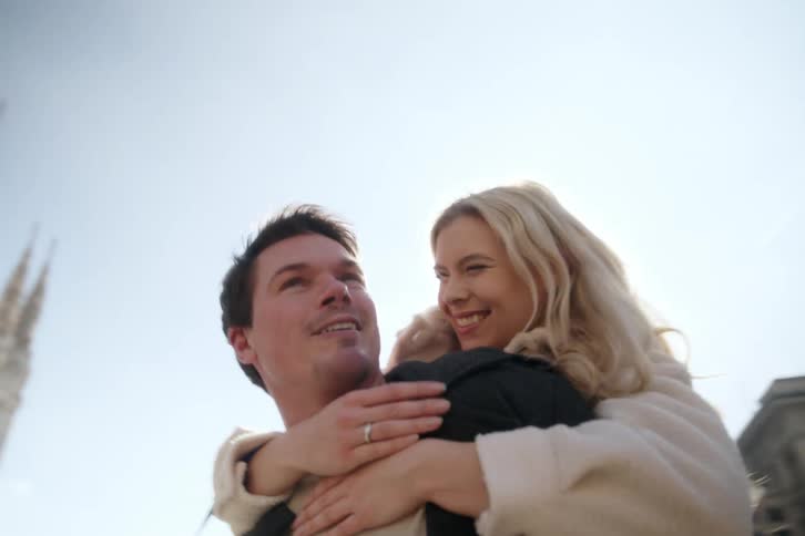 Couple next to a classic cathedral happily kissing