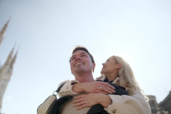 Happy couple hugging together next to a gothic church