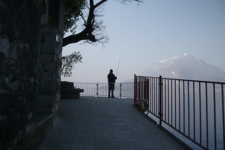 A man is fishing off the stone walkway