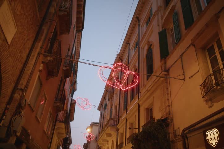 Two hearts are lit up on a sign on a building in a city