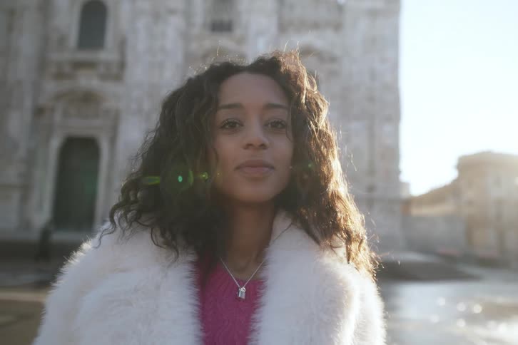 A woman smiles as she stands in front of a cathedral