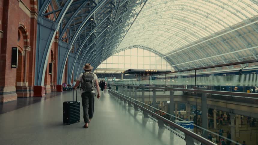 A man rolls his suitcase in London St Pancras station