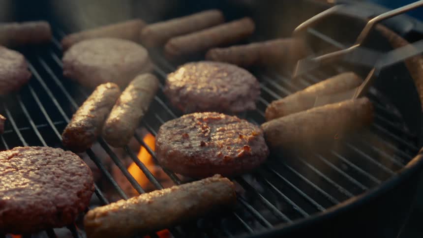 Turning over hamburger patty on a bbq