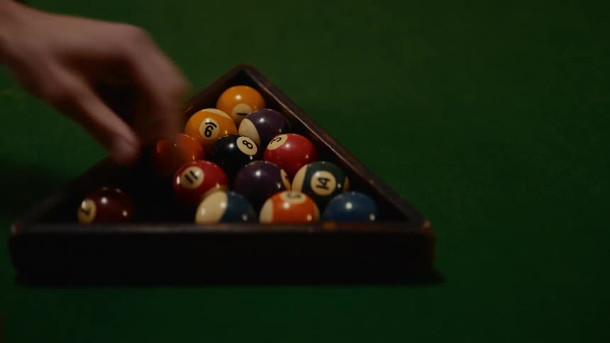 Placing the objects balls in the rack to start a game of pool