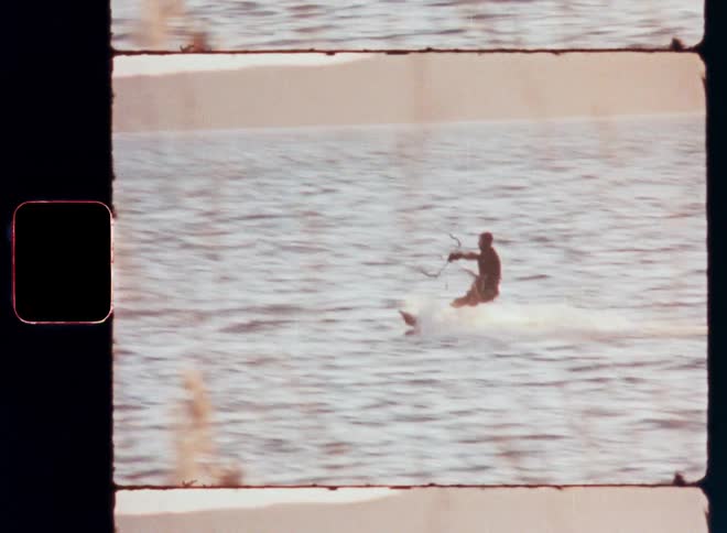 A man is water skiing near a beach