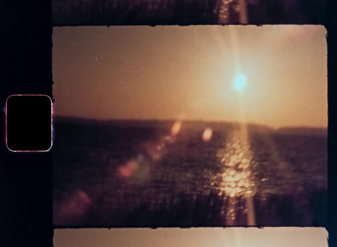 Sunset over the sea and a person paragliding