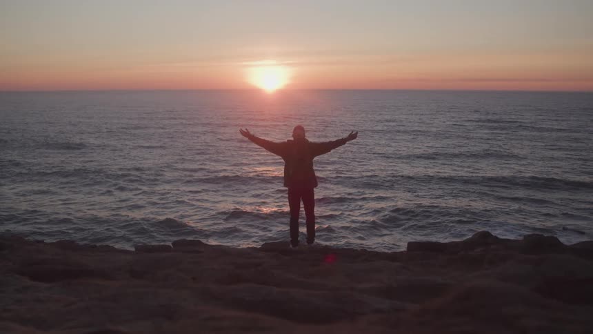 A footage of a person standing by the sea shore